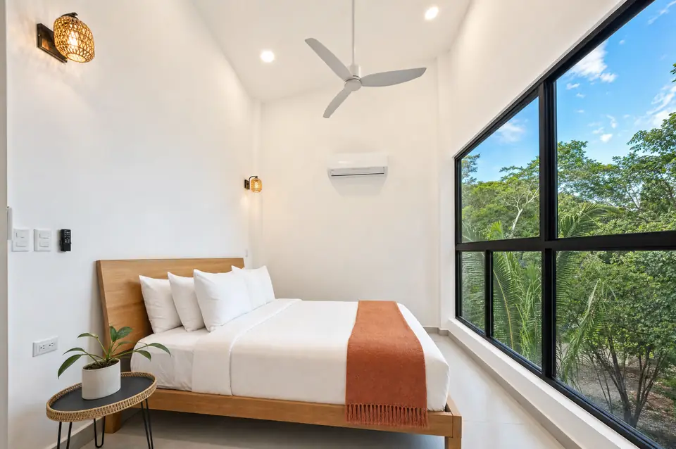 Casa Guiones bedroom with linen bed and jungle-facing shutters